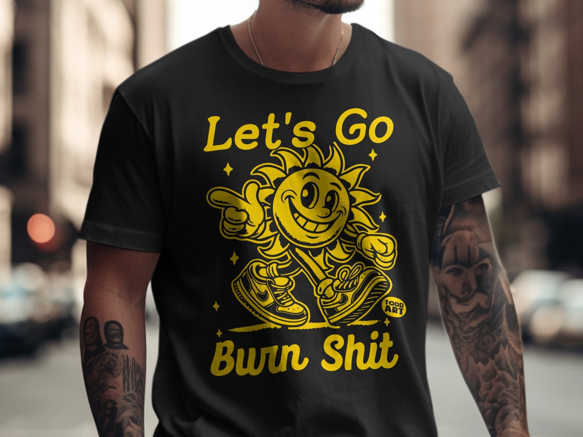 Black t-shirt with "Let's Go Burn Shit" text and smiling sun graphic.