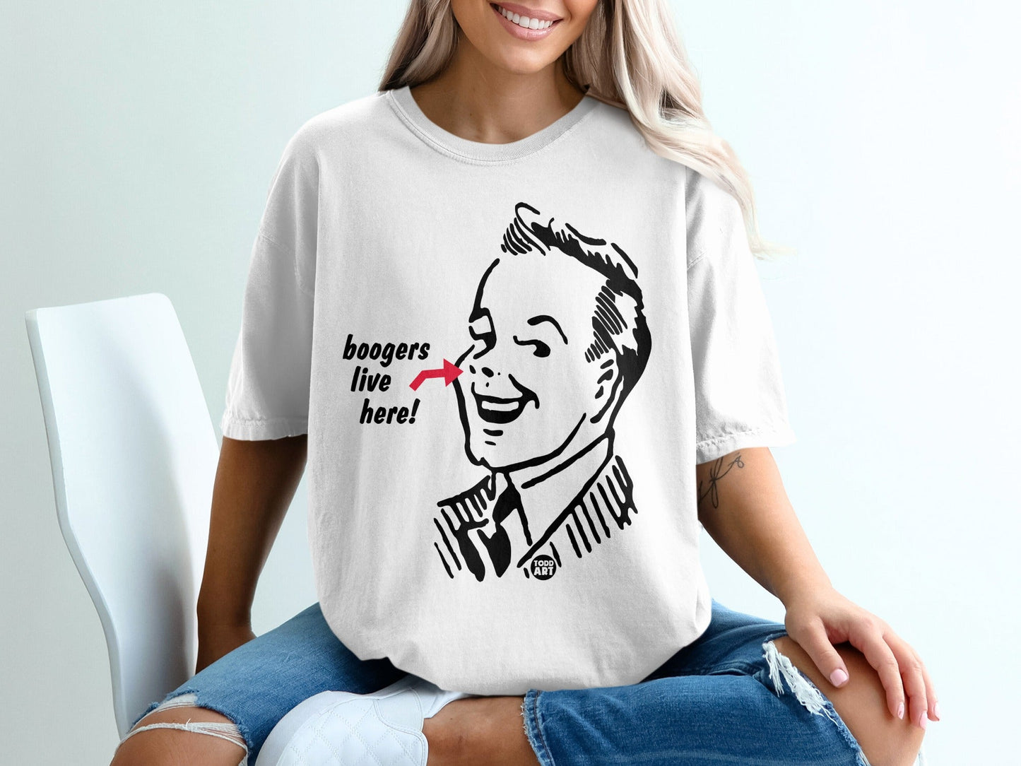 White t-shirt with black illustration of a man's face and "boogers live here" text.