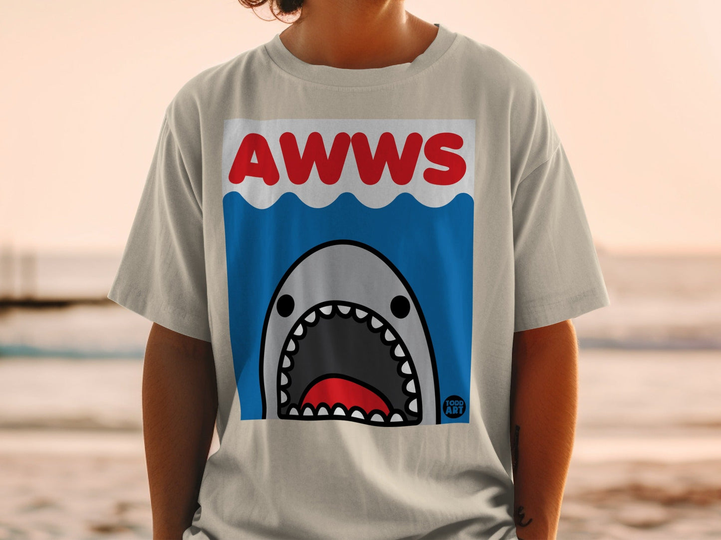 T-shirt with a cartoon shark face and "AWWS" text in a blue wave design.