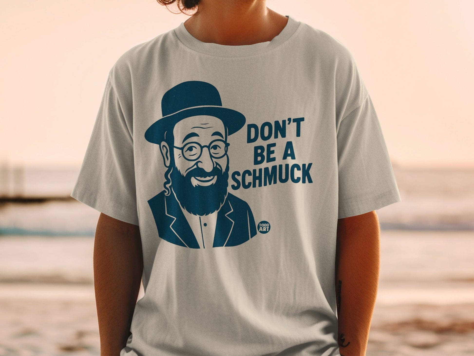 T-shirt with a cartoon man in a hat and glasses, text reads "DON'T BE A SCHMUCK."