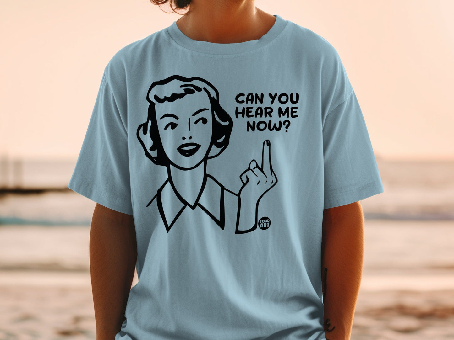 Light blue t-shirt with woman's illustration and text "CAN YOU HEAR ME NOW?".