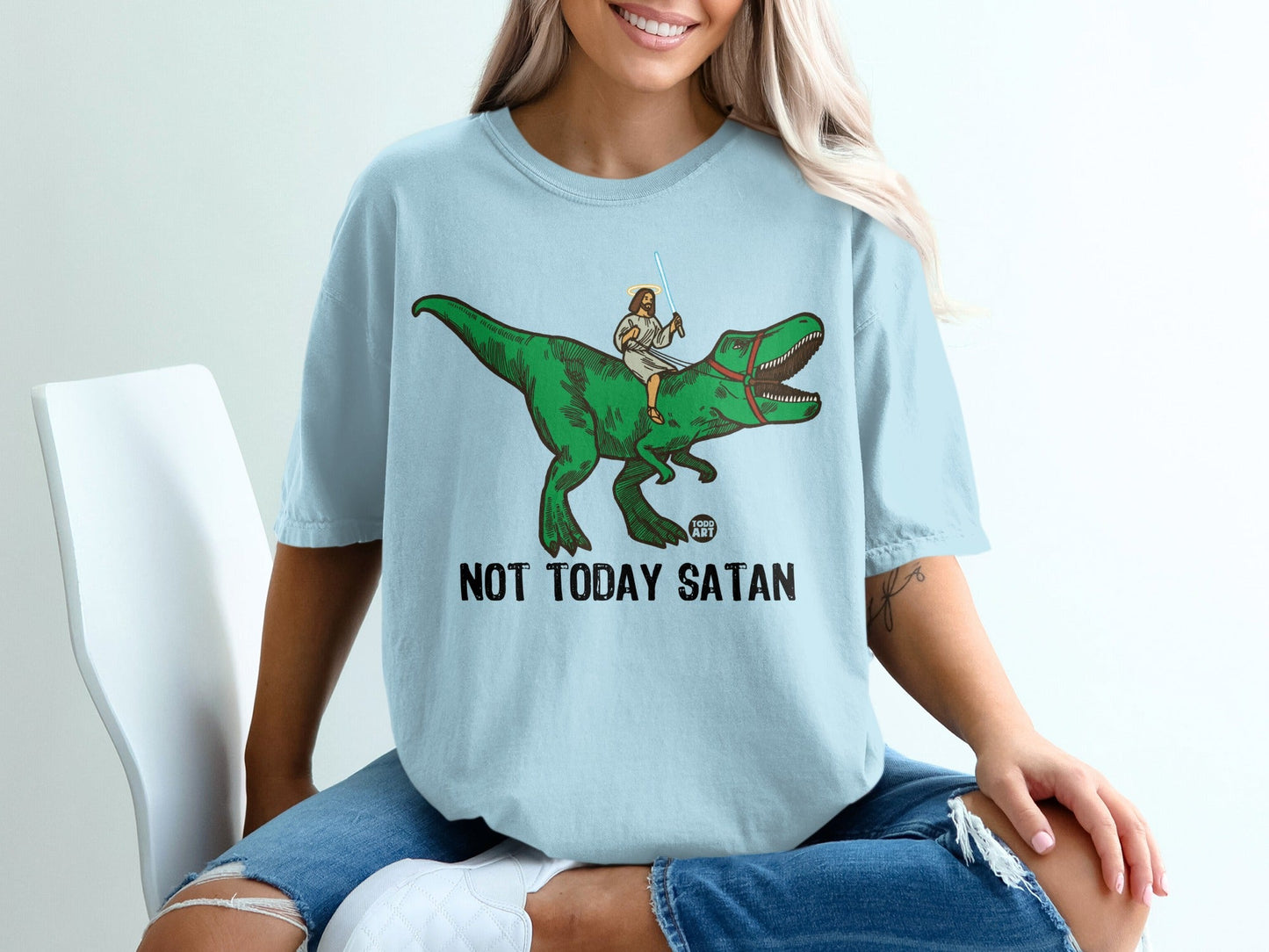 Jesus rides a dinosaur holding a lightsaber, text says "NOT TODAY SATAN".
