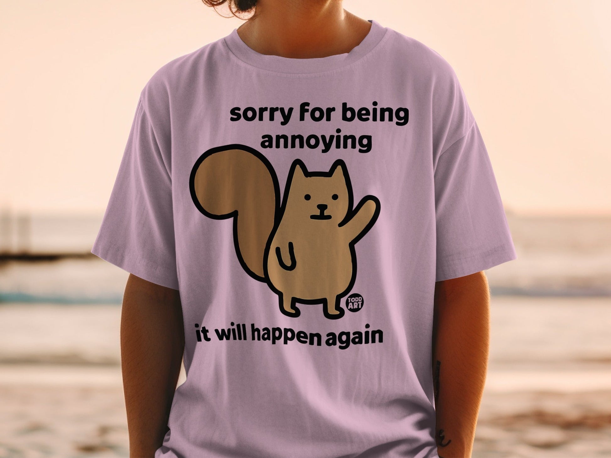 Pink t-shirt with cartoon squirrel saying "sorry for being annoying it will happen again."