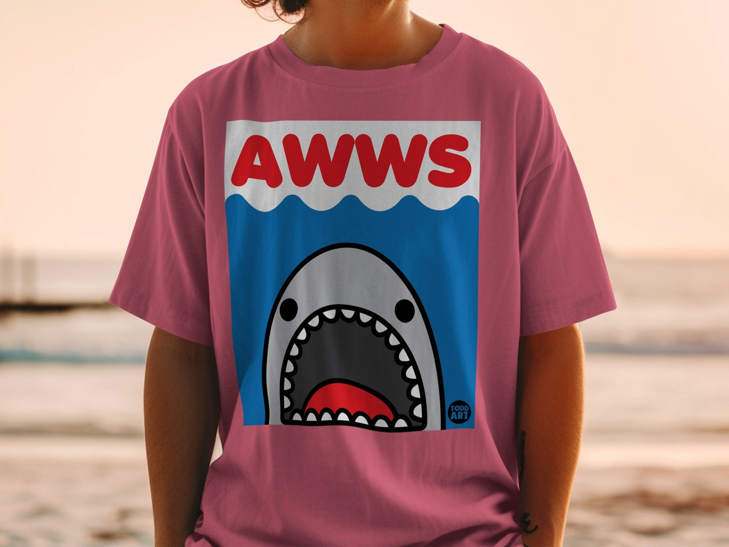 Pink t-shirt with cartoon shark and text "AWWS" and "FOOD ART".