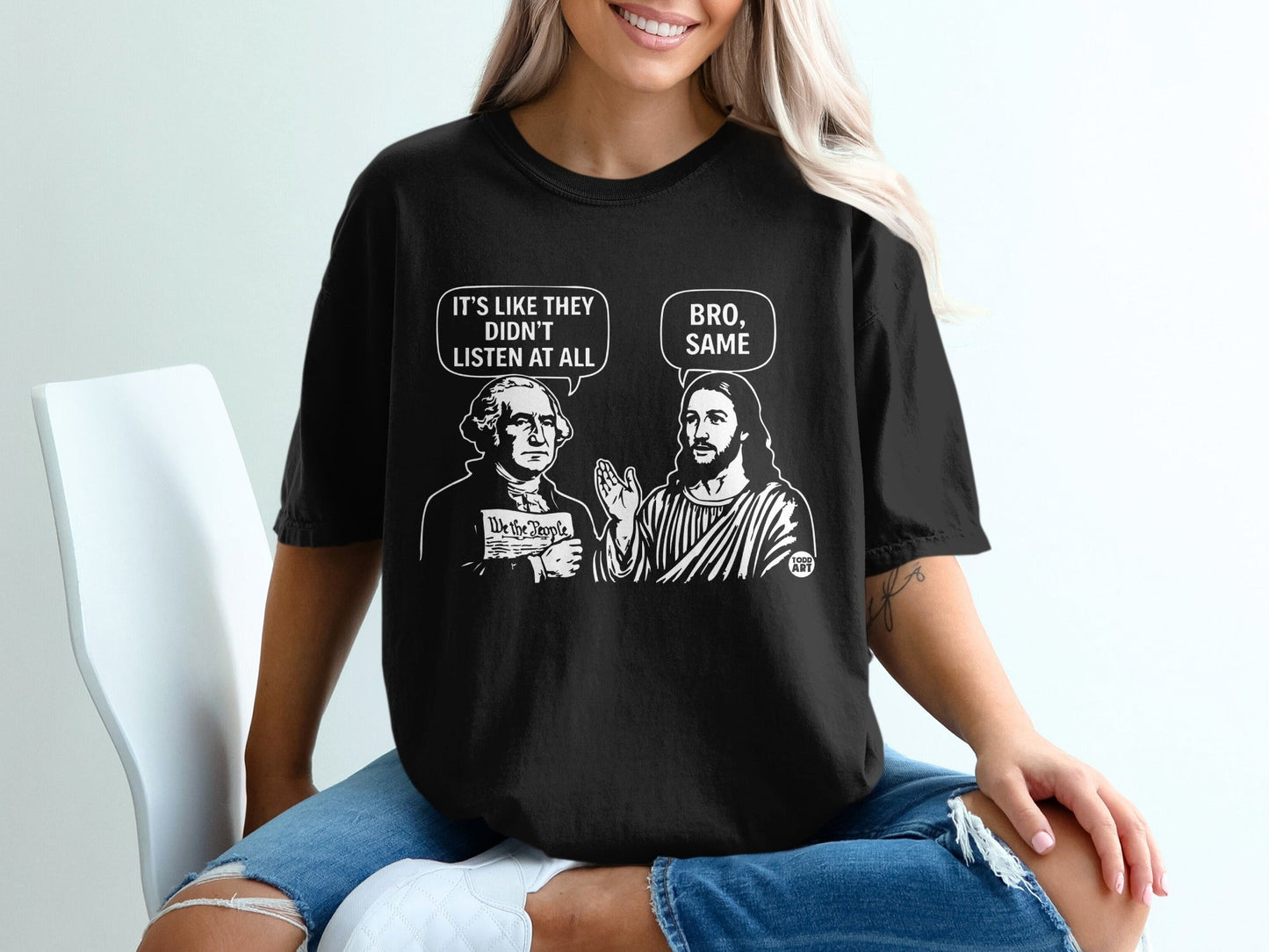 Black t-shirt graphic of George Washington and Jesus discussing "We the People."