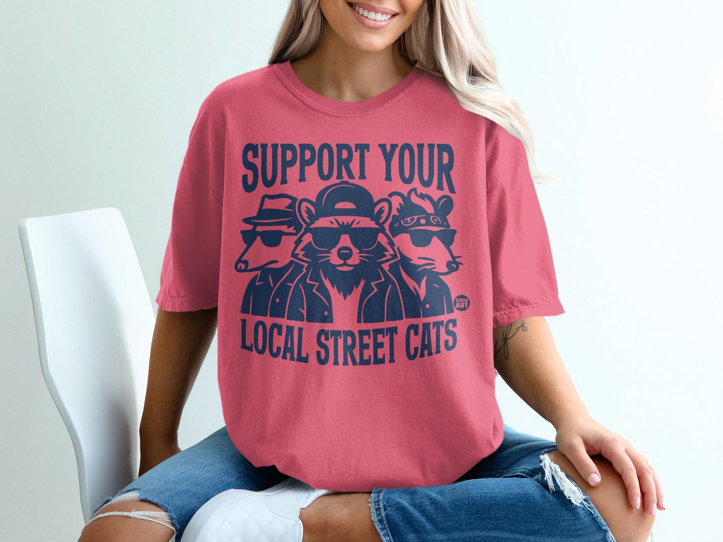 T-shirt with navy graphic: "Support Your Local Street Cats" featuring three raccoons.