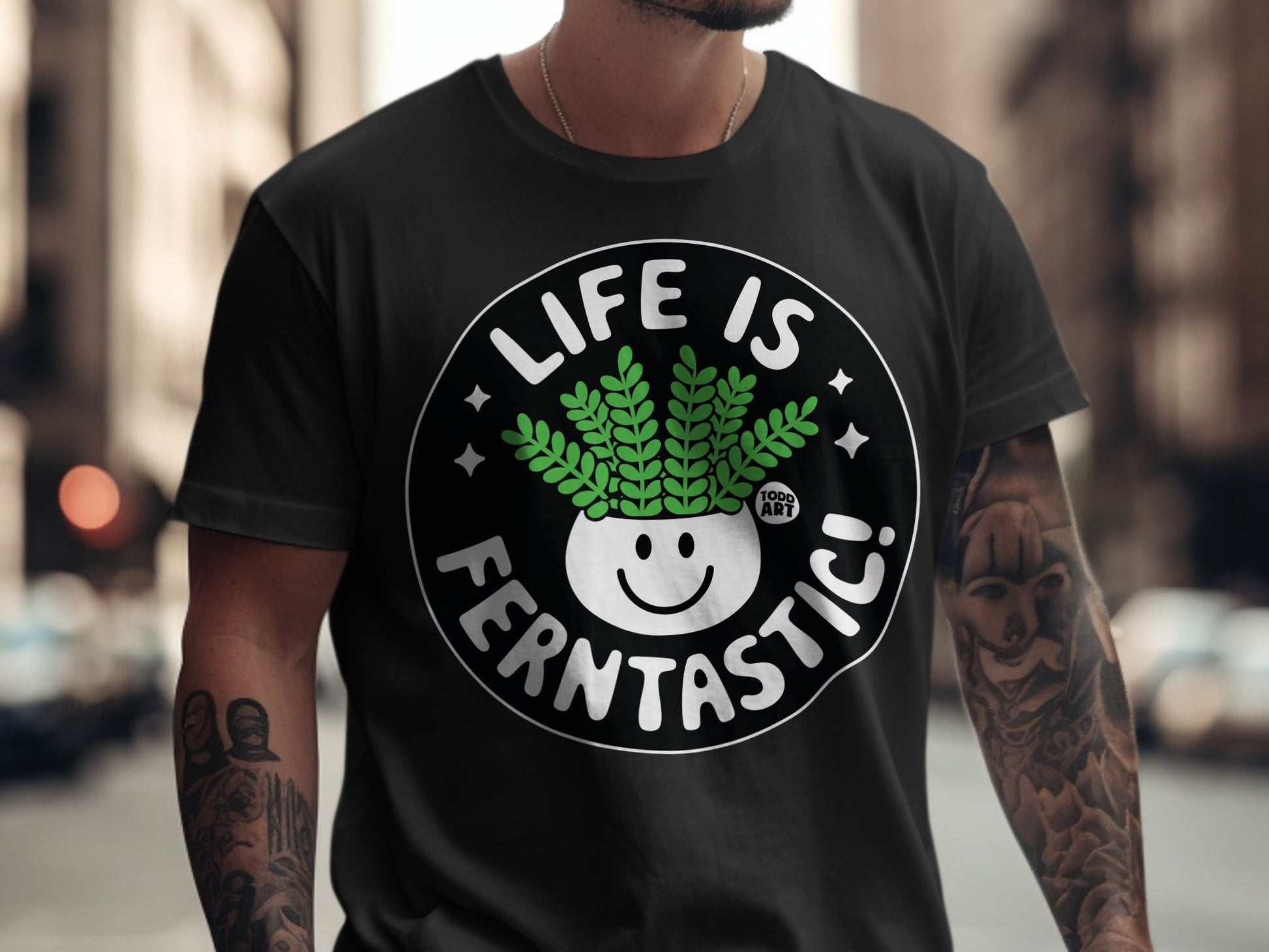 Black t-shirt with "Life is Fern-tastic!" text and smiling fern pot graphic.