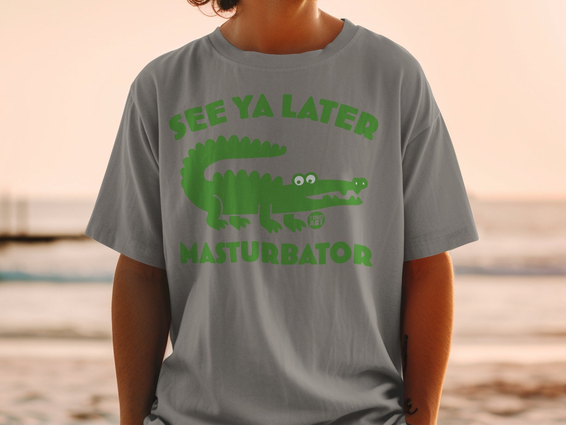 Green alligator graphic with "SEE YA LATER MASTURBATOR" text on grey t-shirt.