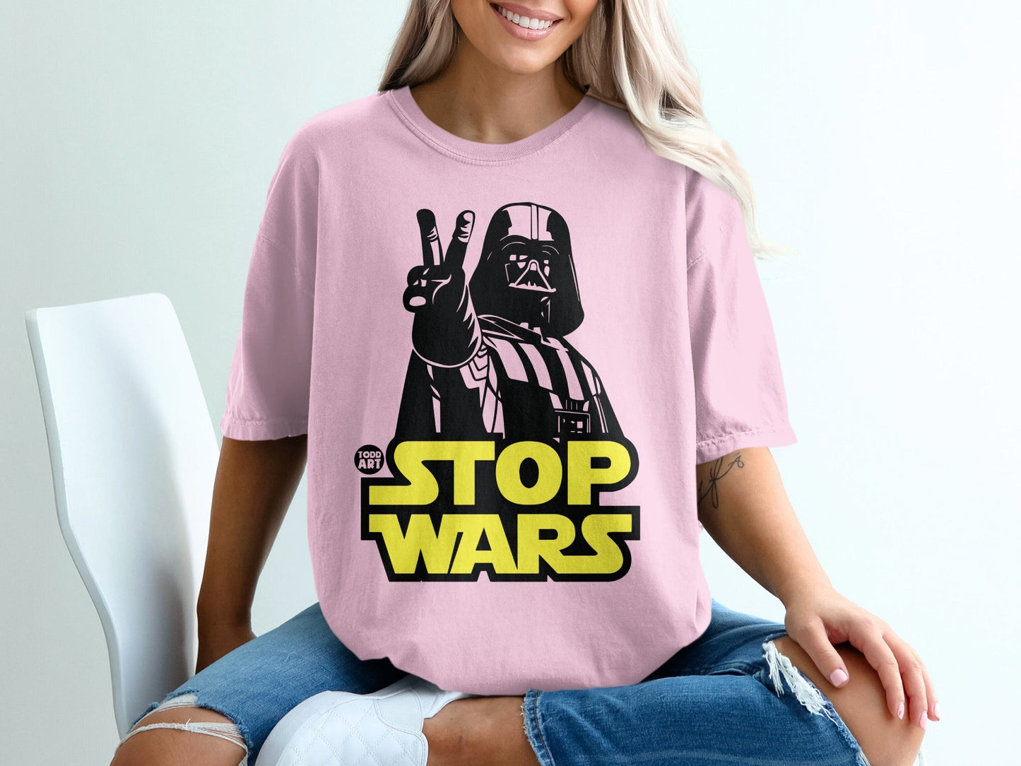 Pink t-shirt with Darth Vader giving a peace sign and "STOP WARS" text.