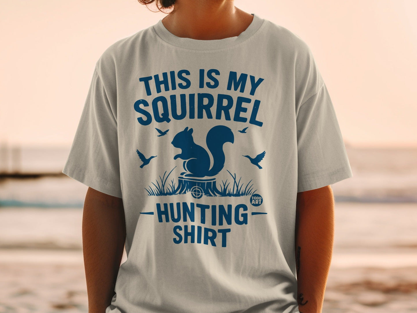 Blue graphic t-shirt with a squirrel, tree stump, and birds.