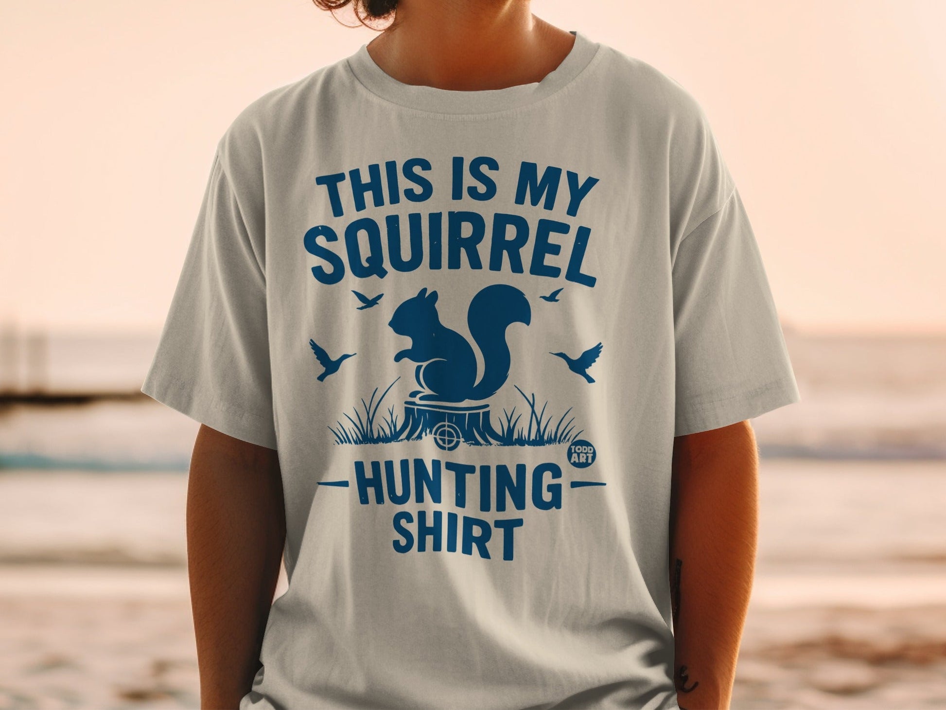 Blue graphic t-shirt with a squirrel, tree stump, and birds.