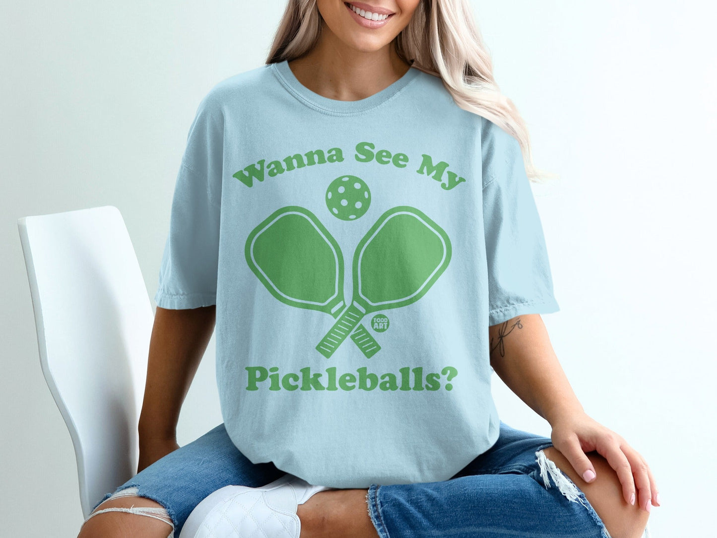 Light blue t-shirt with "Wanna See My Pickleballs?" and pickleball paddles graphic.