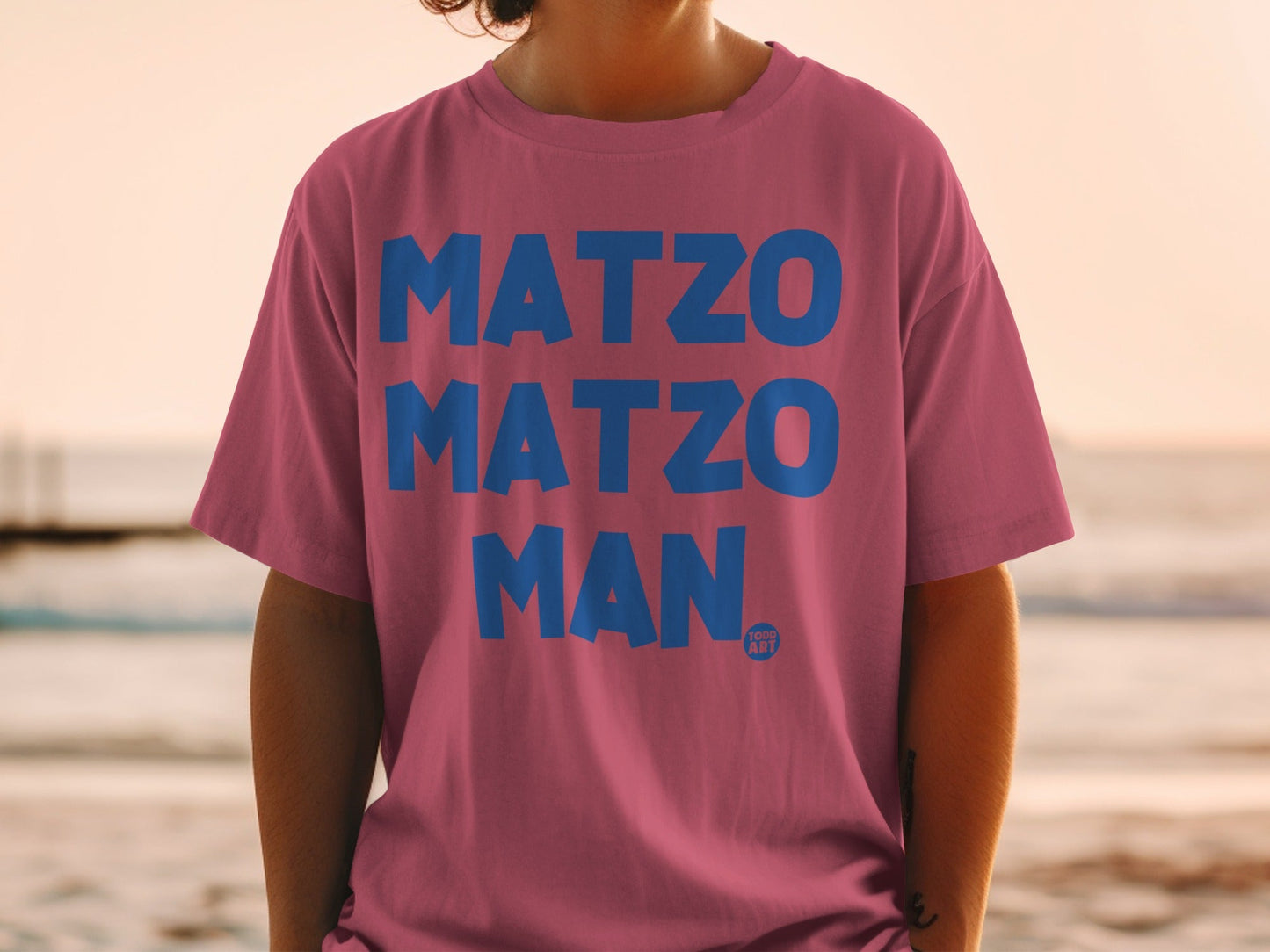 Pink t-shirt with blue text "MATZO MATZO MAN" and a small logo.