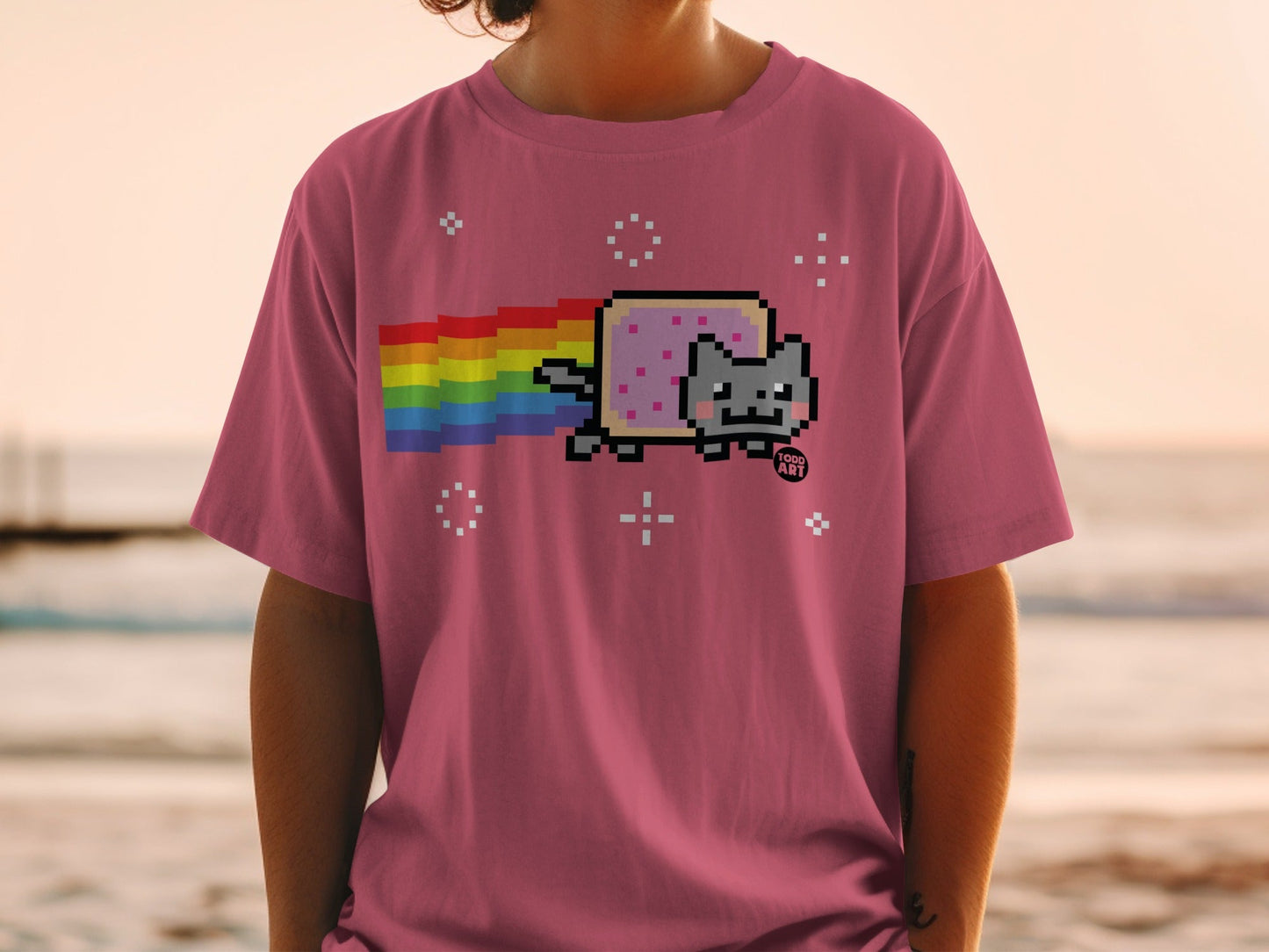 Pink t-shirt with pixelated Nyan Cat and rainbow trail.