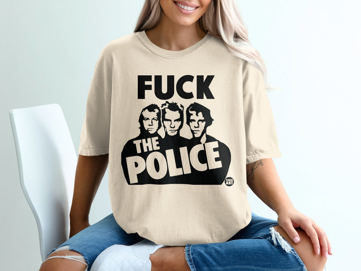 Cream t-shirt with black "The Police" band members graphic.