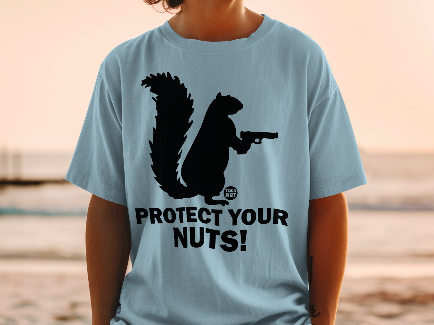 T-shirt with a silhouette of a squirrel holding a gun, text reads "Protect Your Nuts!".