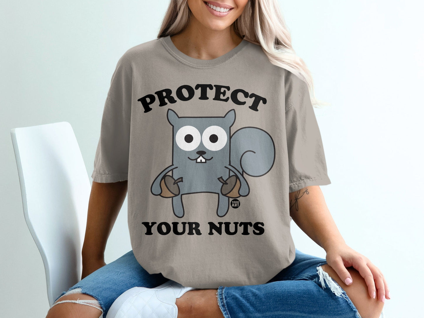 T-shirt with "PROTECT YOUR NUTS" text and a cartoon squirrel holding acorns.