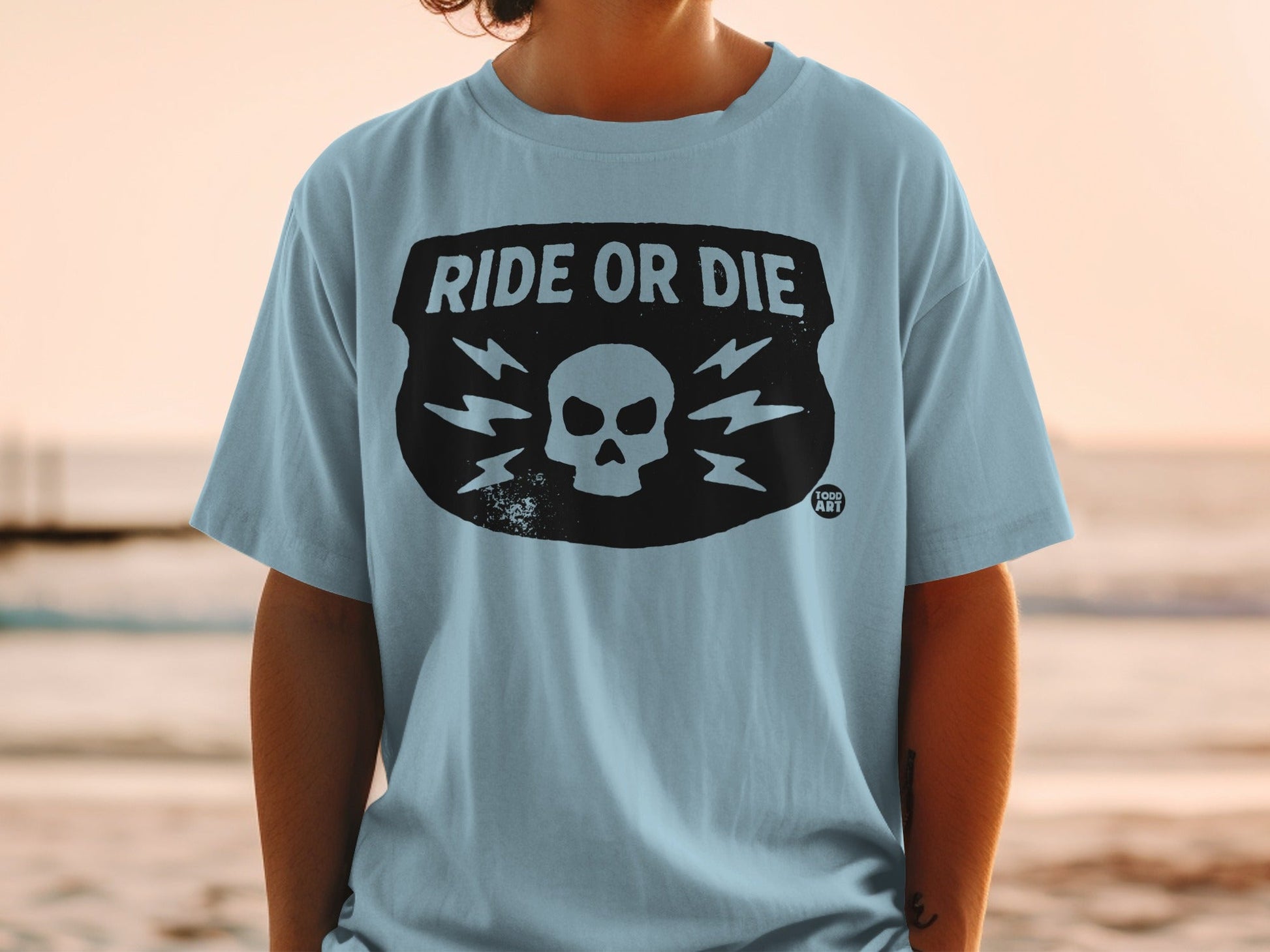 Light blue t-shirt with "RIDE OR DIE" and skull graphic.
