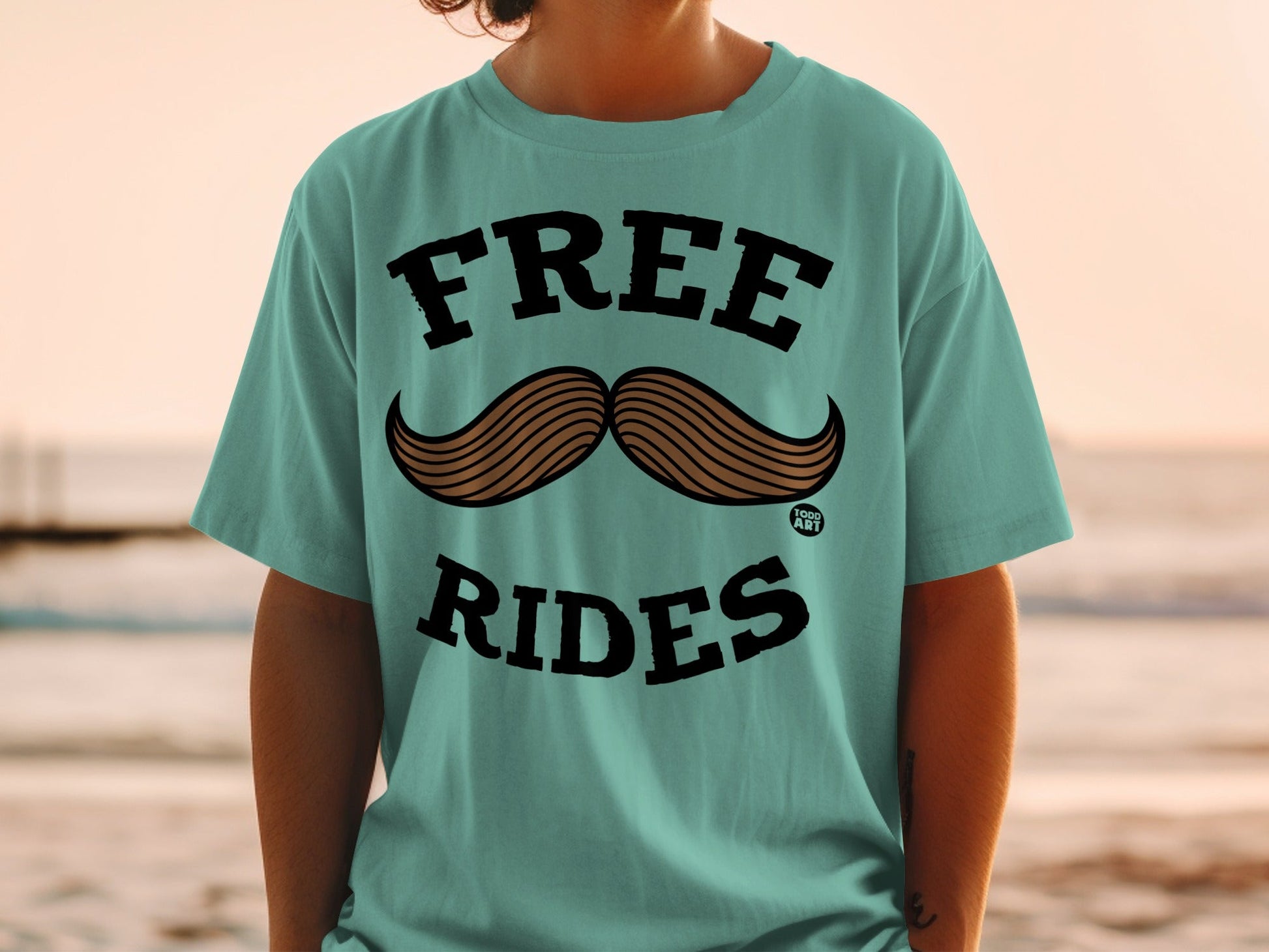 Teal t-shirt with "FREE RIDES" and a large mustache graphic.