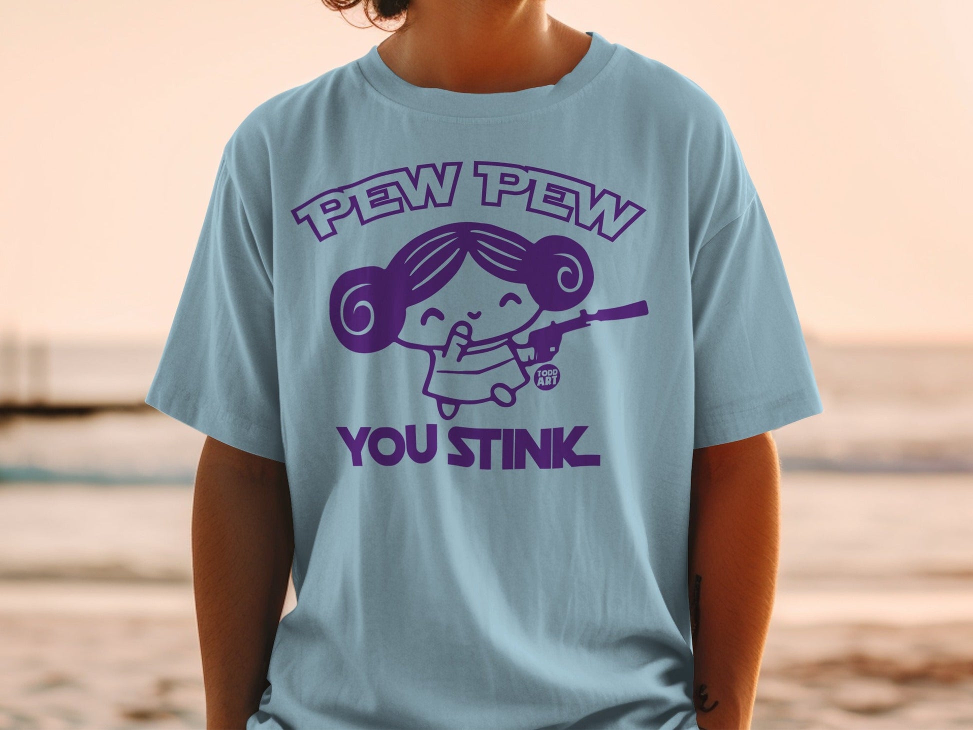 Light blue t-shirt with "Pew Pew You Stink" text and a cartoon character holding a blaster.