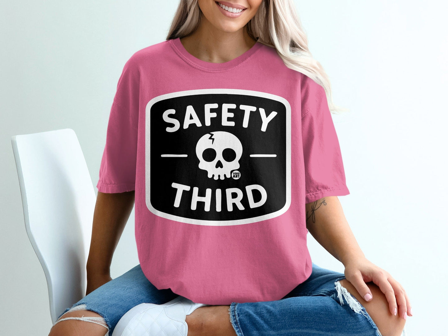Pink t-shirt with black "SAFETY THIRD" text and skull logo.