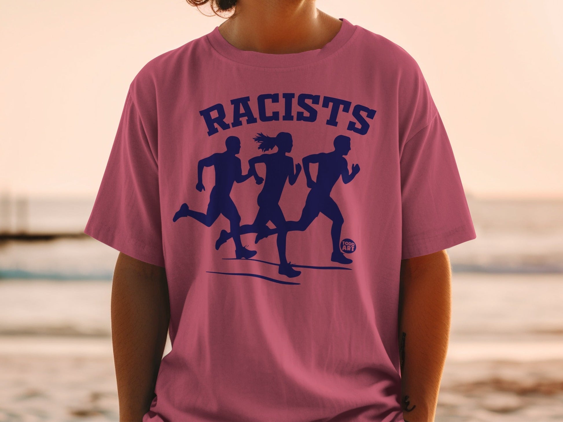 Pink t-shirt with navy blue graphic of three running figures and "RACISTS" text.