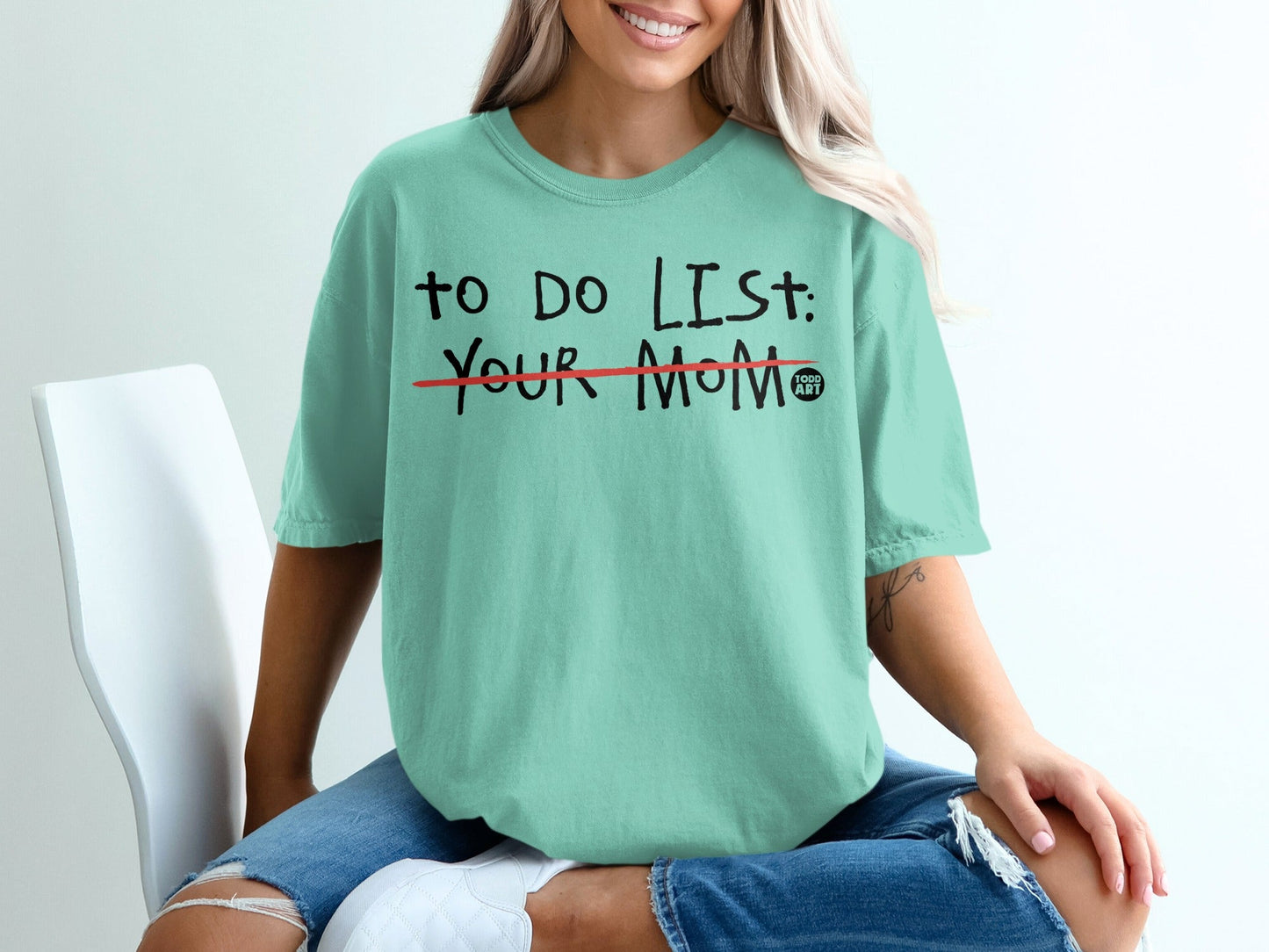 Teal t-shirt with "TO DO LIST: YOUR MOM" printed in black, red line through list.