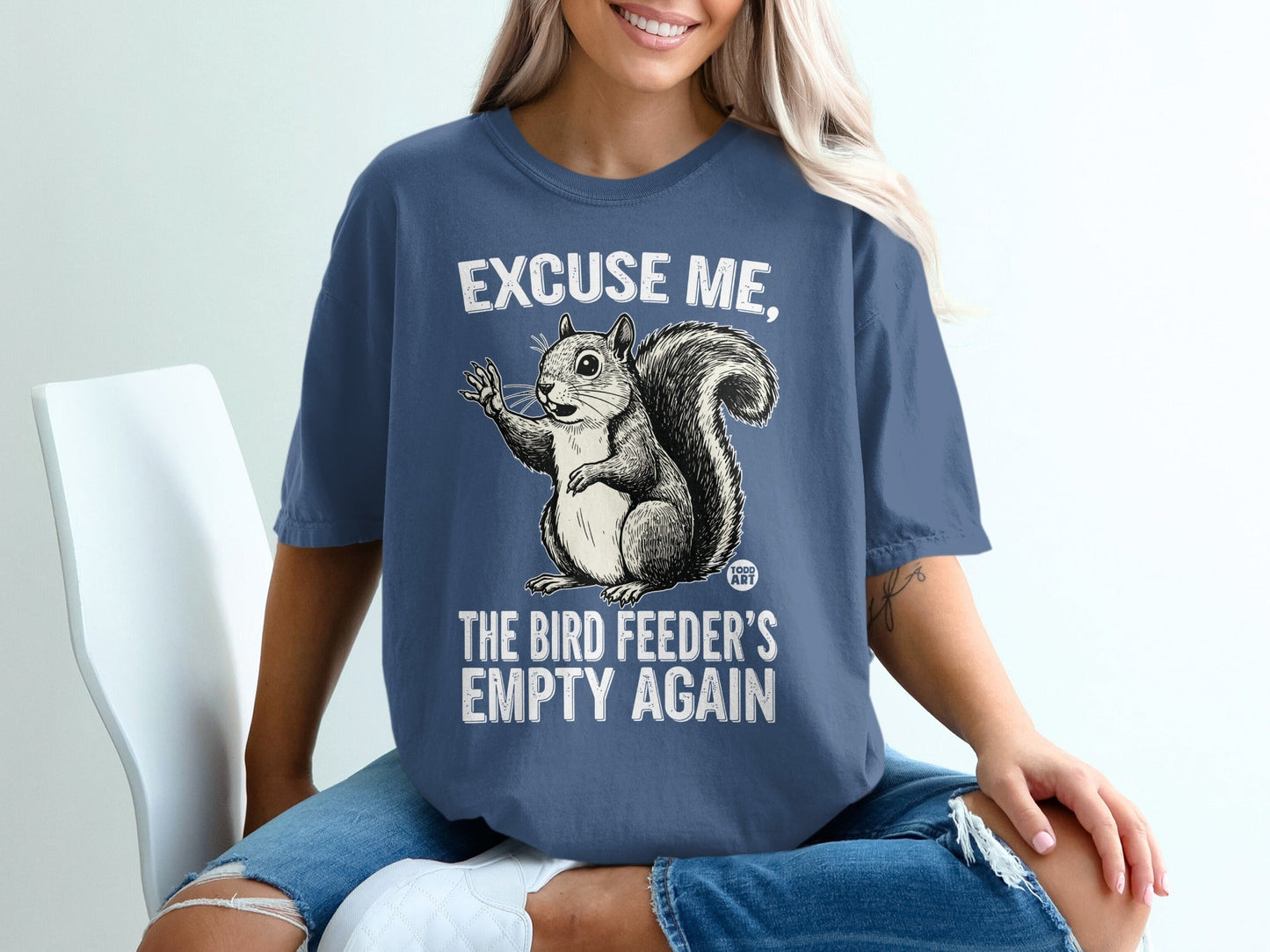 T-shirt with a squirrel and text that says "Excuse me, the bird feeder's empty again."