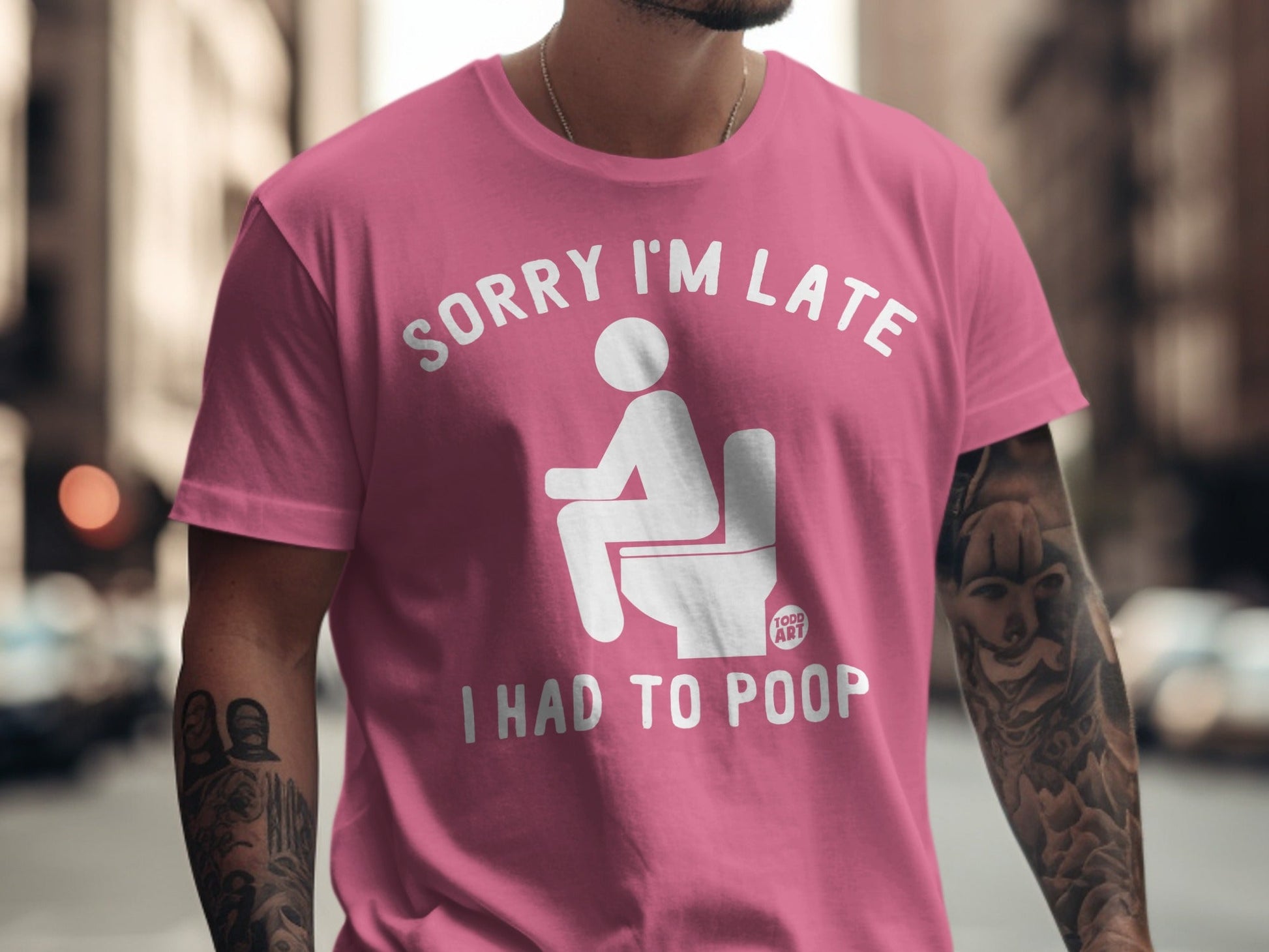 Pink t-shirt with "Sorry I'm Late I Had To Poop" graphic.
