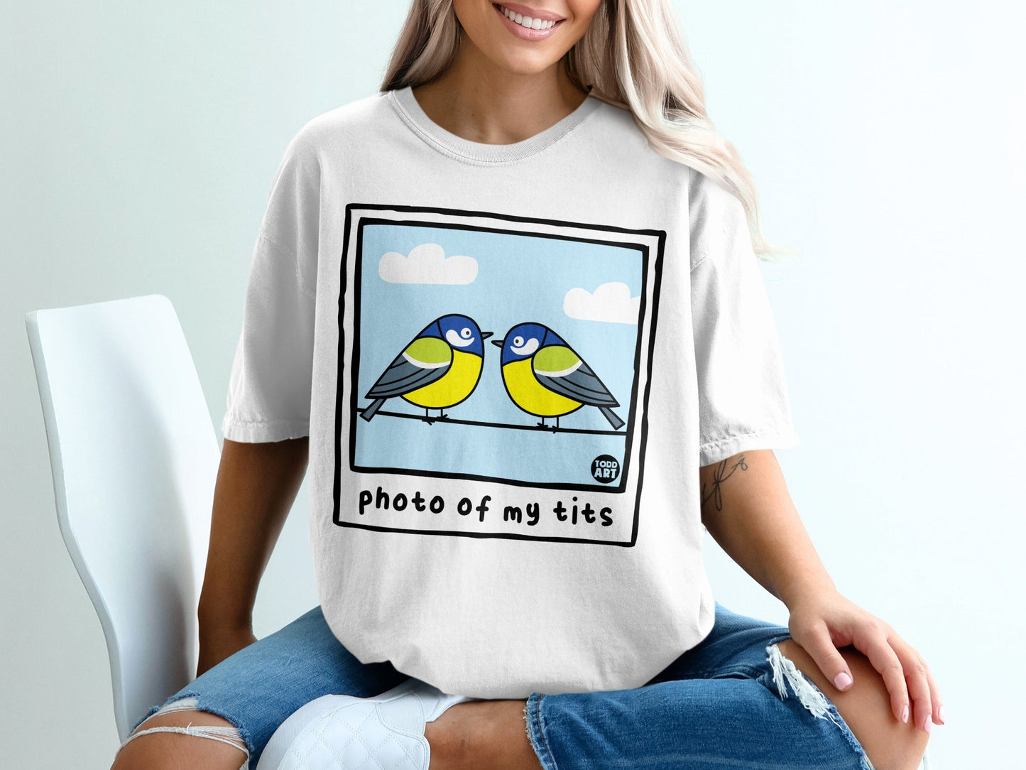 White t-shirt with polaroid graphic of two blue and yellow birds on a wire.