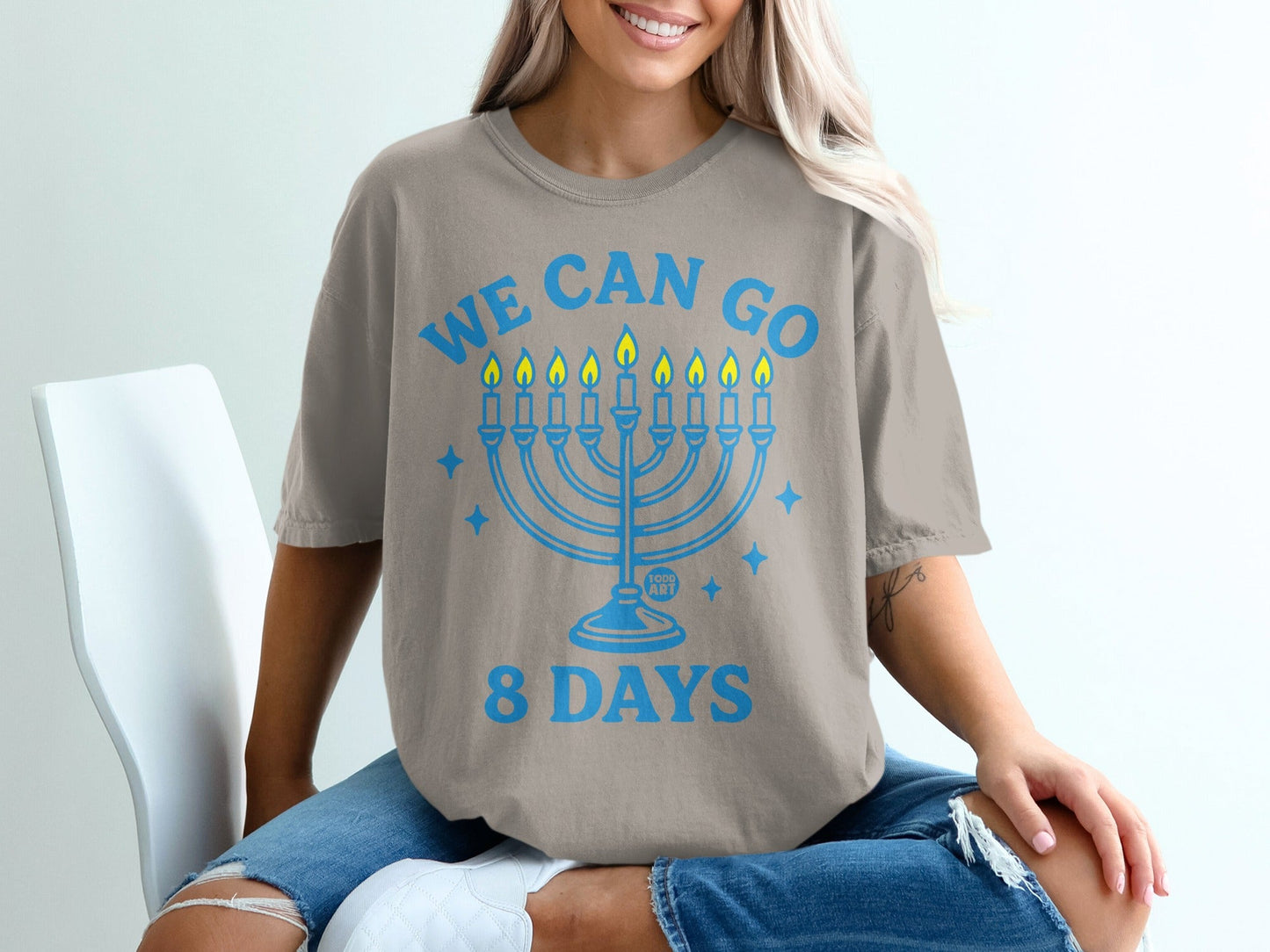 Light blue graphic on gray t-shirt reading "WE CAN GO 8 DAYS" with menorah.