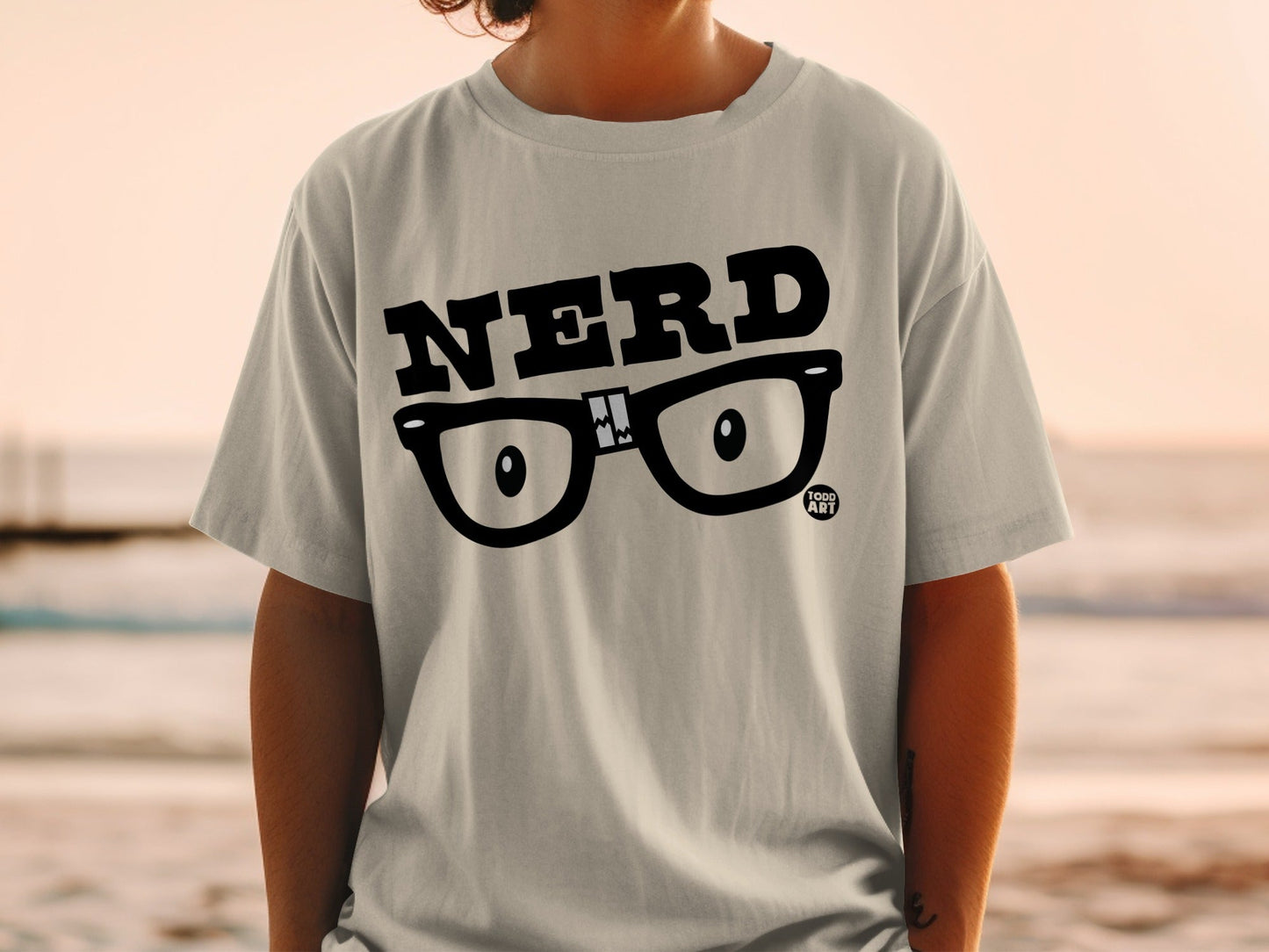 Light grey t-shirt with black "NERD" text and cartoon glasses graphic.