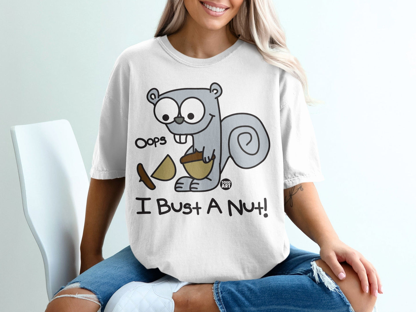 Cartoon squirrel with acorn shirt saying "Oops I Bust A Nut!"