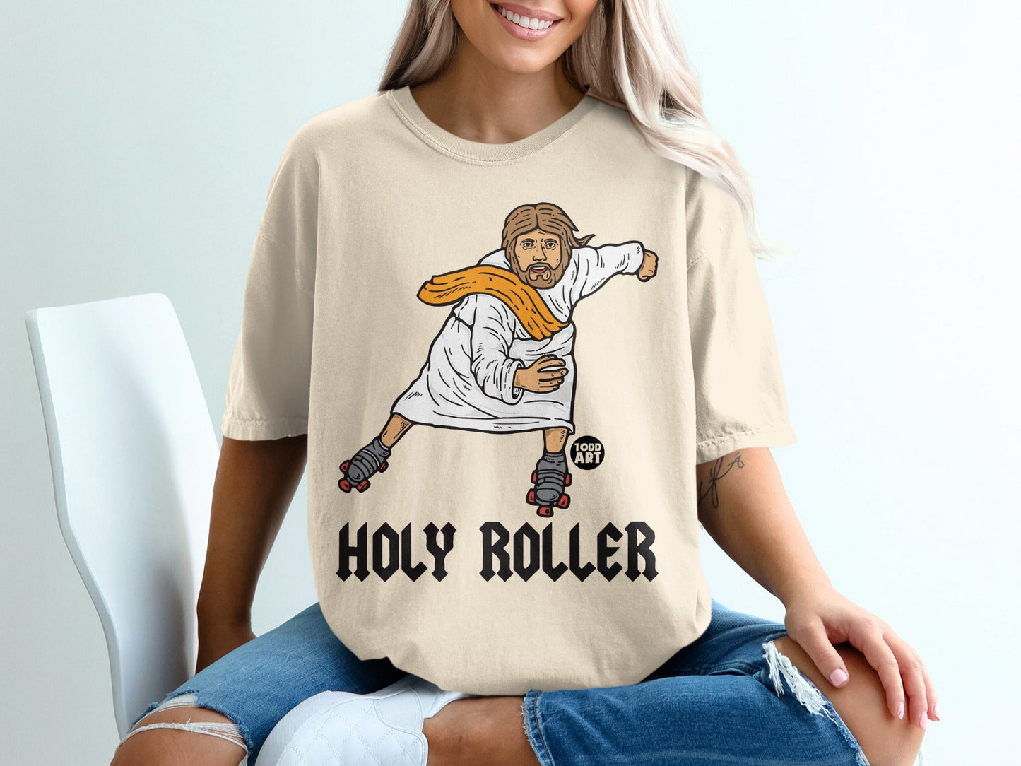 Jesus on roller skates wearing a white robe and orange scarf, text "HOLY ROLLER".