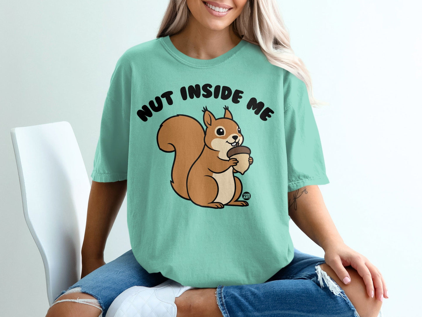Teal t-shirt with a cartoon squirrel holding an acorn and the text "NUT INSIDE ME."