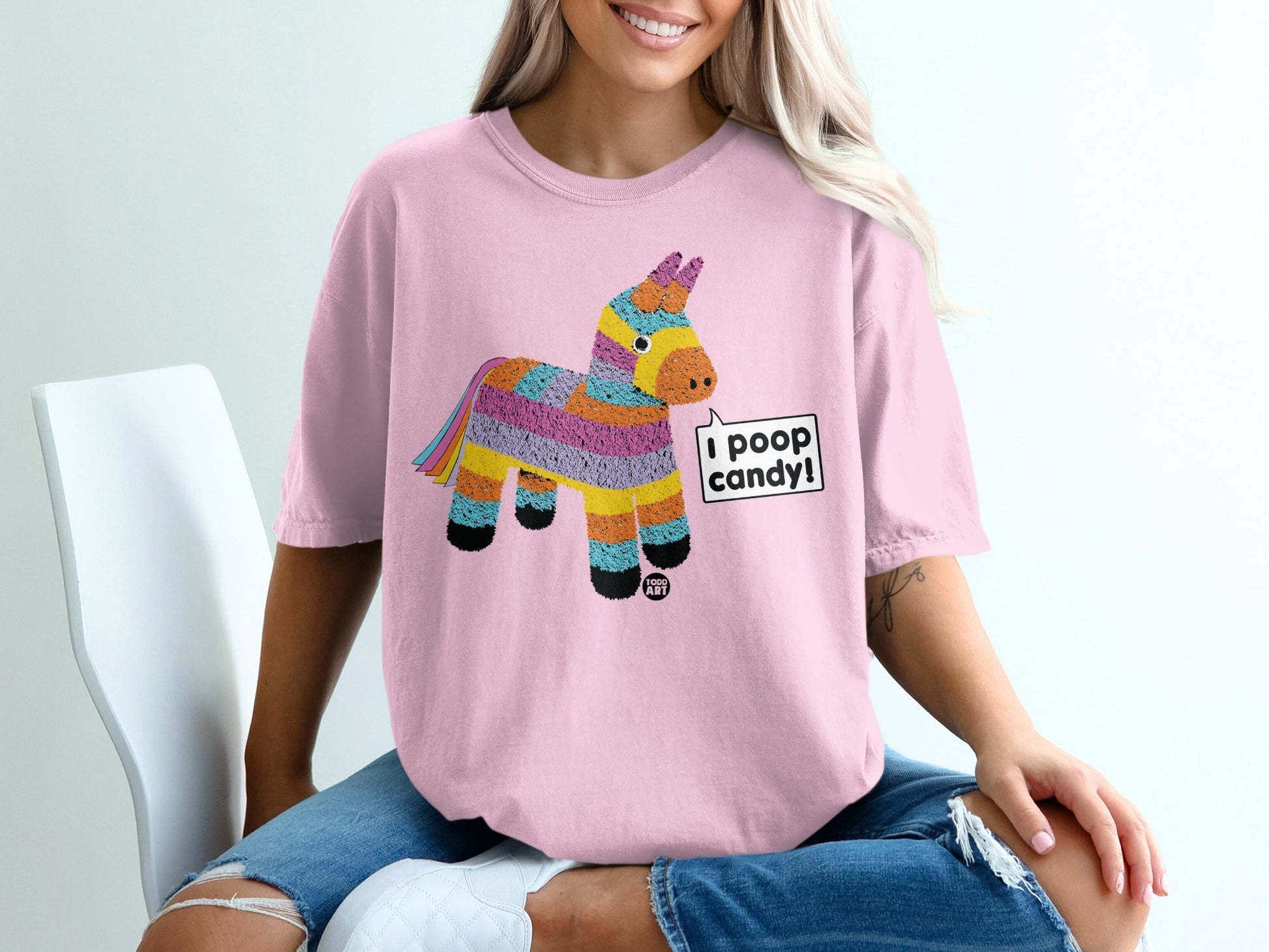 Pink t-shirt with a colorful pi√±ata graphic that says "I poop candy!"