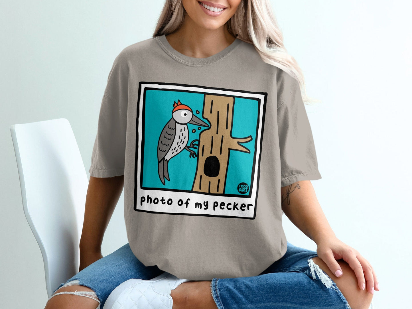 Illustration of a cartoon woodpecker on a tree trunk with the text "photo of my pecker".