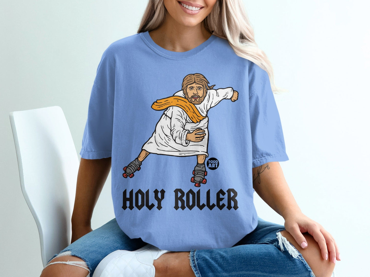 Light blue t-shirt with "Holy Roller" text and graphic of Jesus on roller skates.