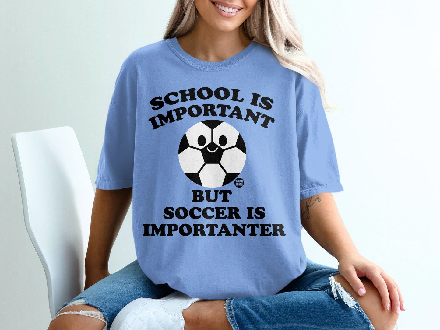 Blue t-shirt with "School is important but soccer is importanter" text and a soccer ball graphic.