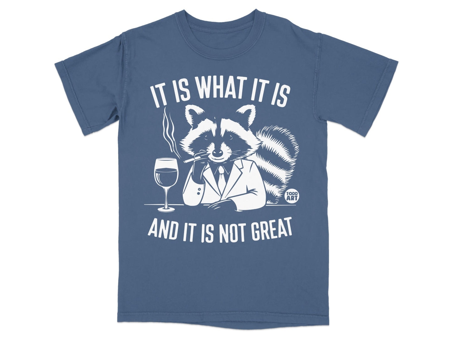 T-shirt with raccoon in suit smoking, holding drink, and saying "It is what it is and it is not great".