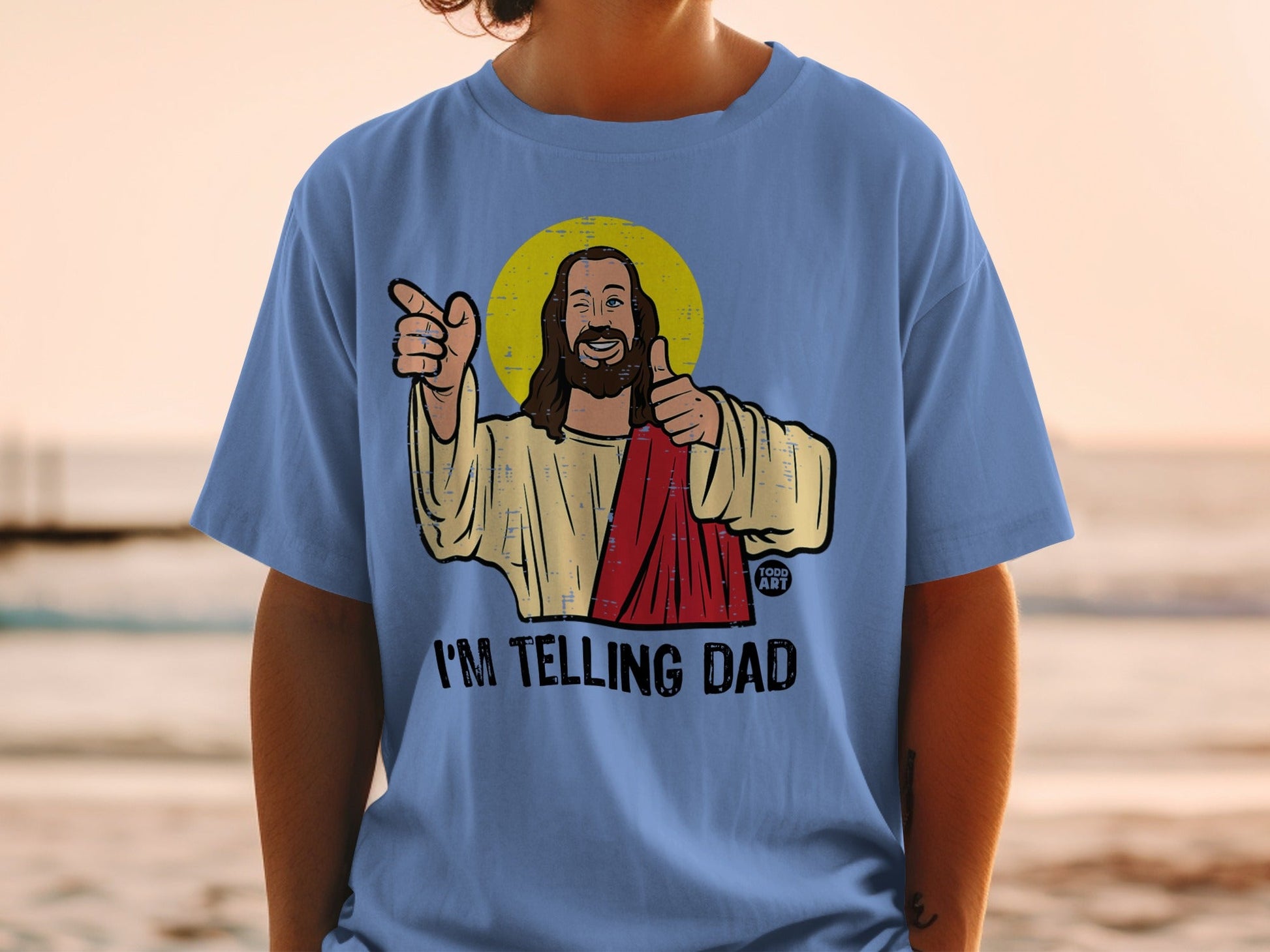 Light blue t-shirt with cartoon Jesus giving a thumbs up and pointing.
