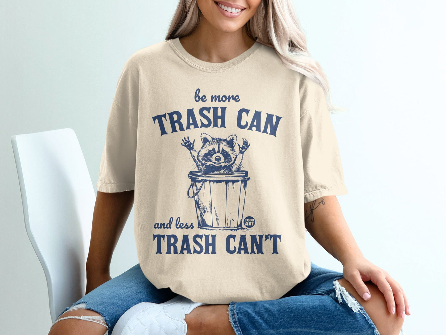 T-shirt with raccoon in trash can saying "be more trash can and less trash can't".