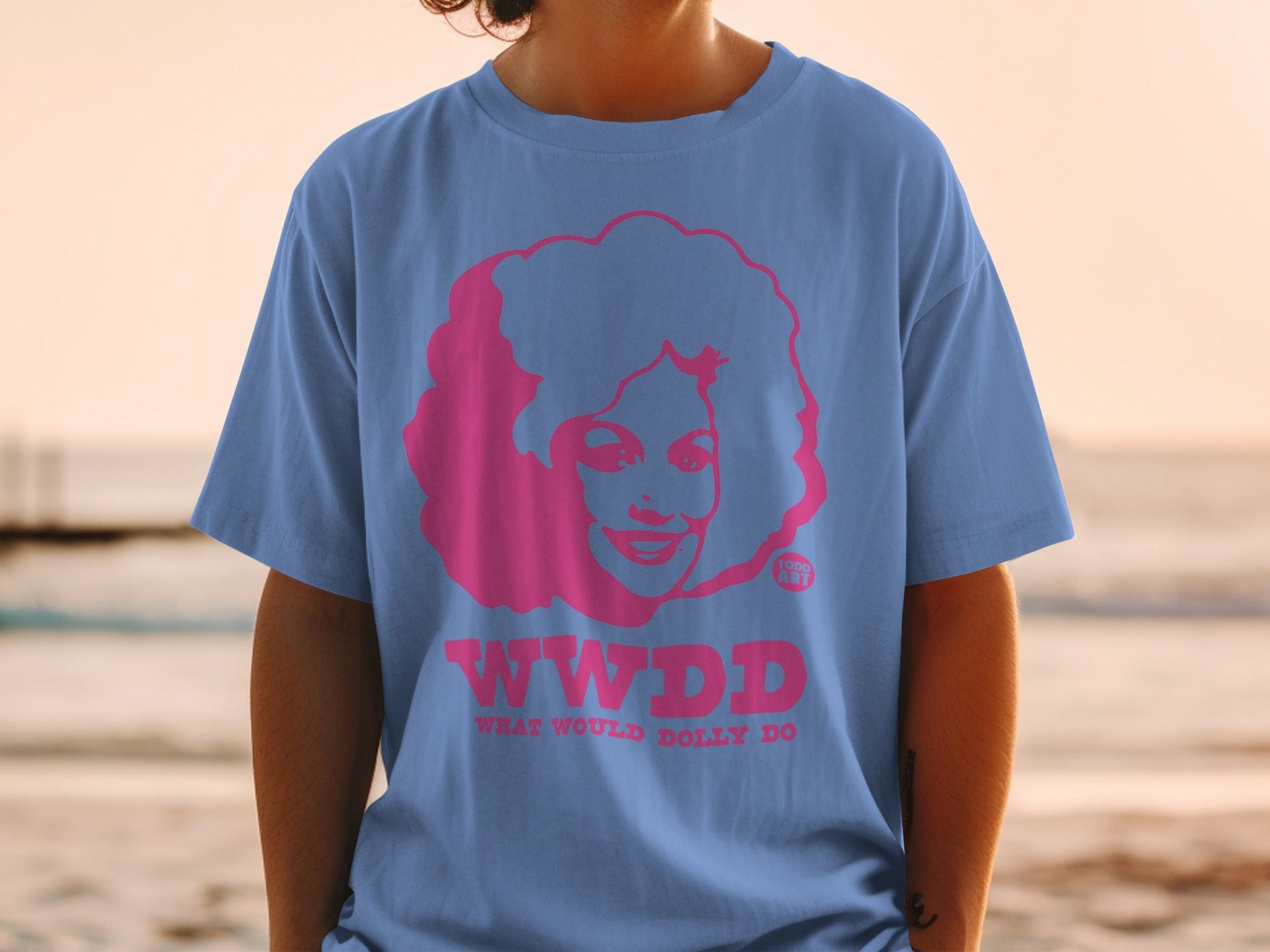 Blue t-shirt featuring pink graphic of Dolly Parton with "WWDD" and "What Would Dolly Do?"