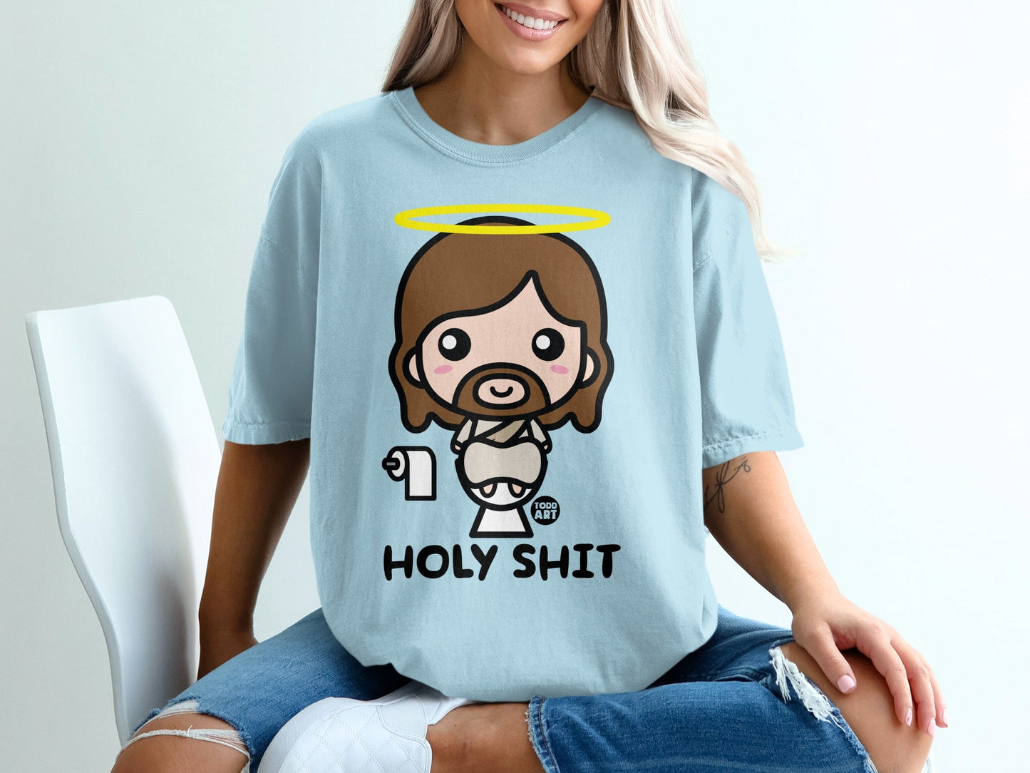 Light blue t-shirt with cartoon Jesus holding toilet paper, text reads HOLY SHIT.