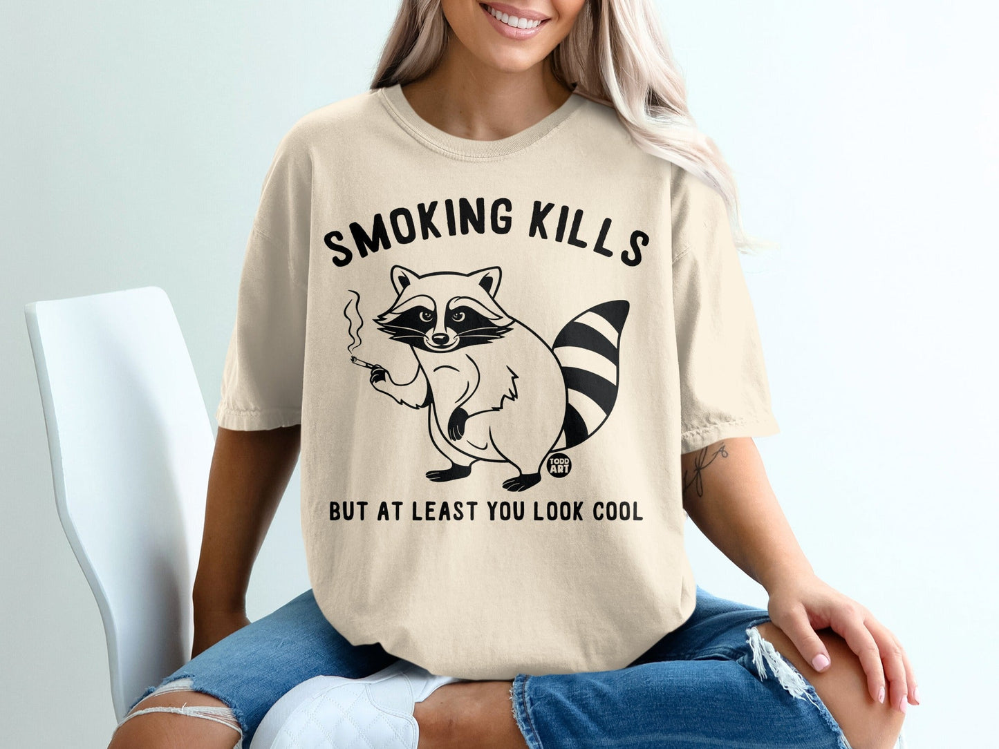 T-shirt with raccoon smoking and text "SMOKING KILLS BUT AT LEAST YOU LOOK COOL."
