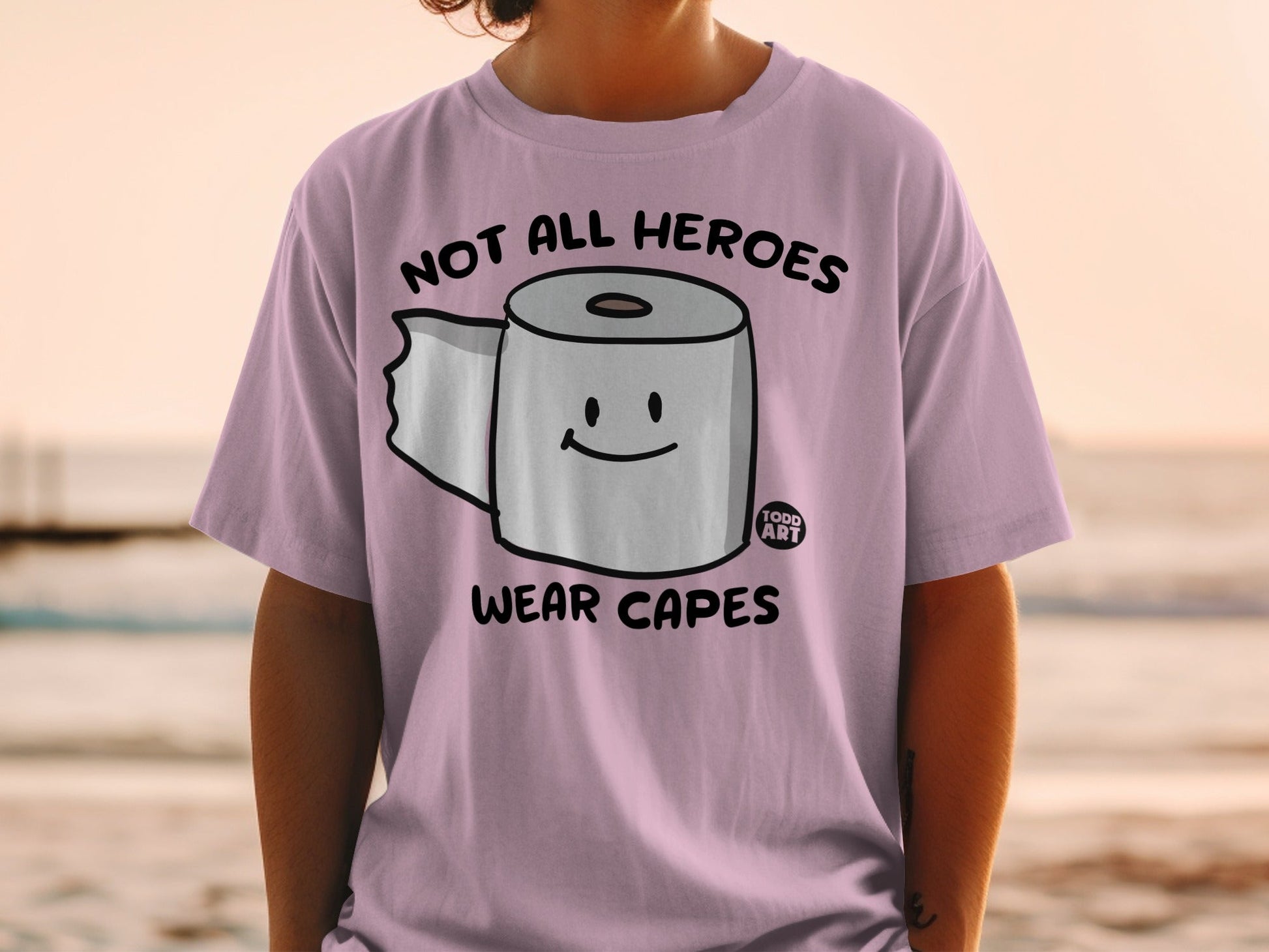 Pink t-shirt with toilet paper saying "Not All Heroes Wear Capes."