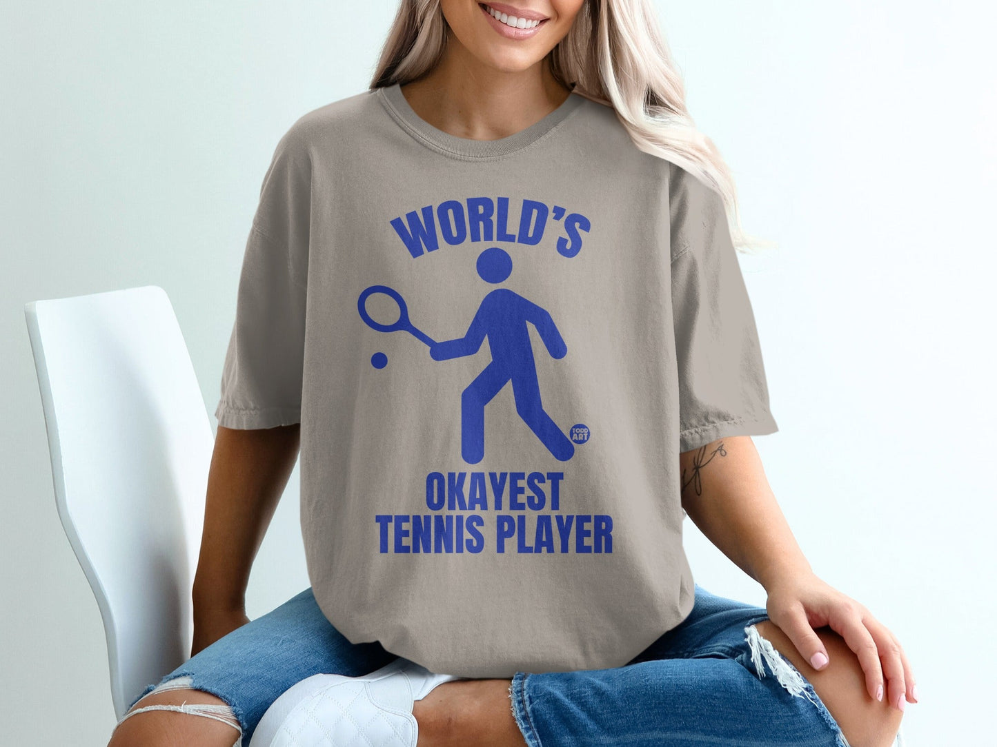 T-shirt with blue graphic and text "WORLD'S OKAYEST TENNIS PLAYER".