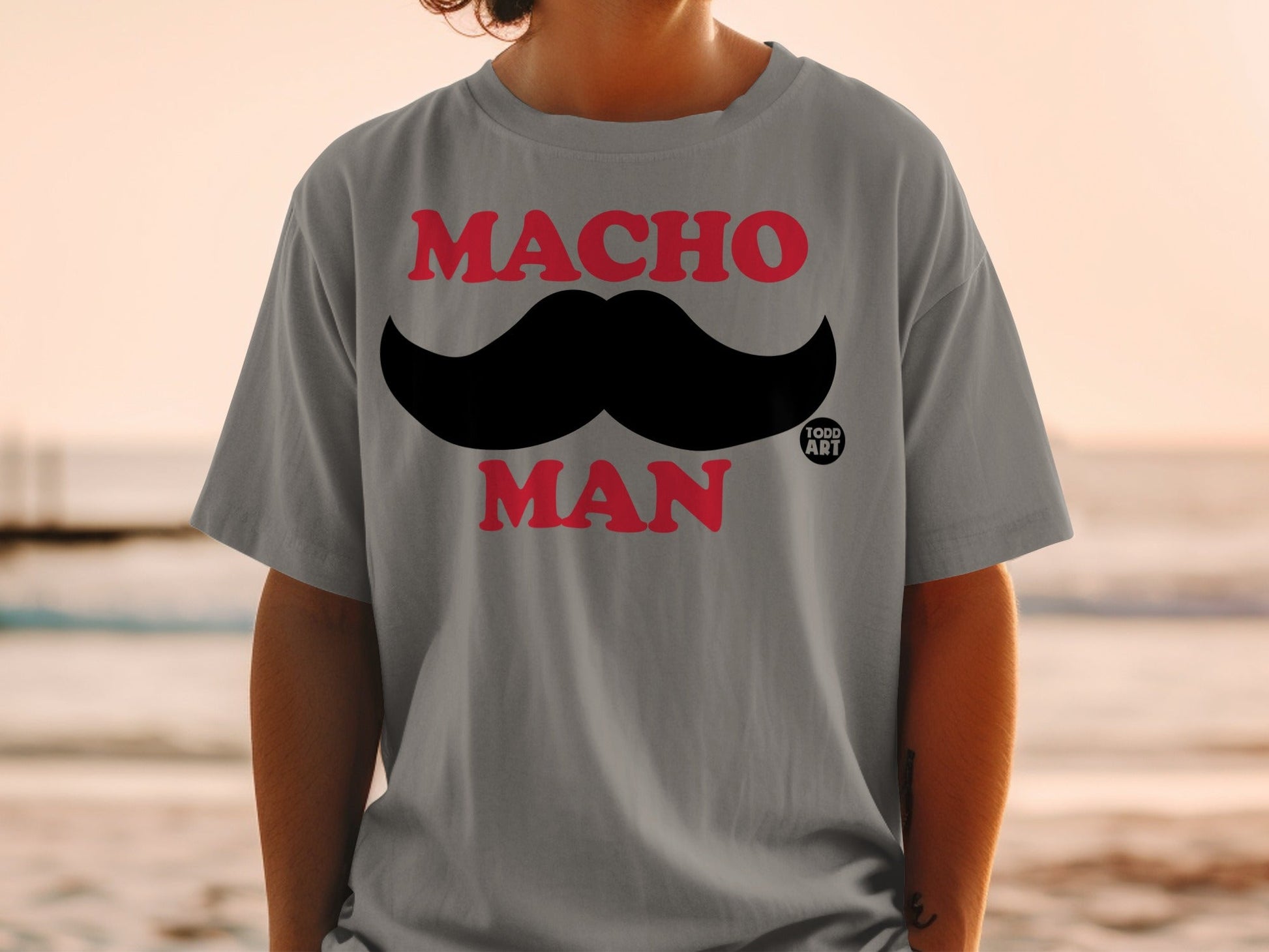 Grey t-shirt with "MACHO MAN" and a black mustache graphic.