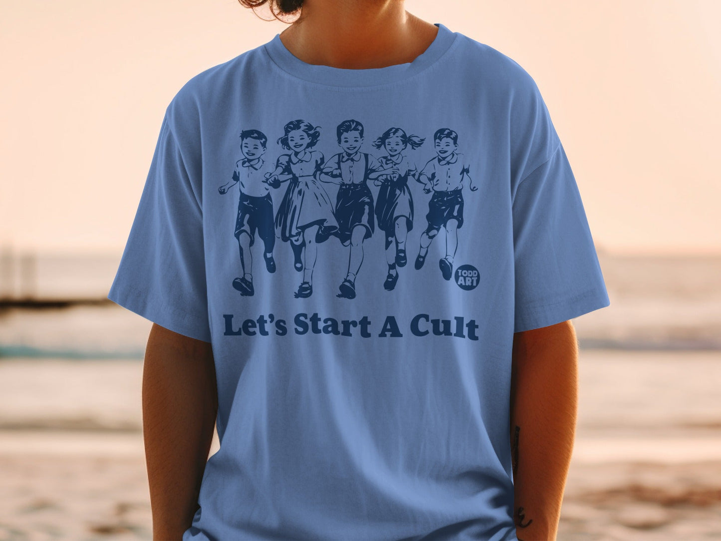 Blue t-shirt with illustration of running children and text "Let's Start A Cult."