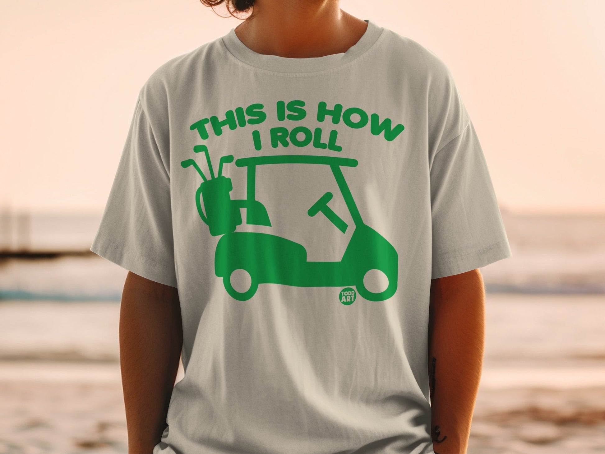 Green golf cart graphic with "This is how I roll" text on a t-shirt.
